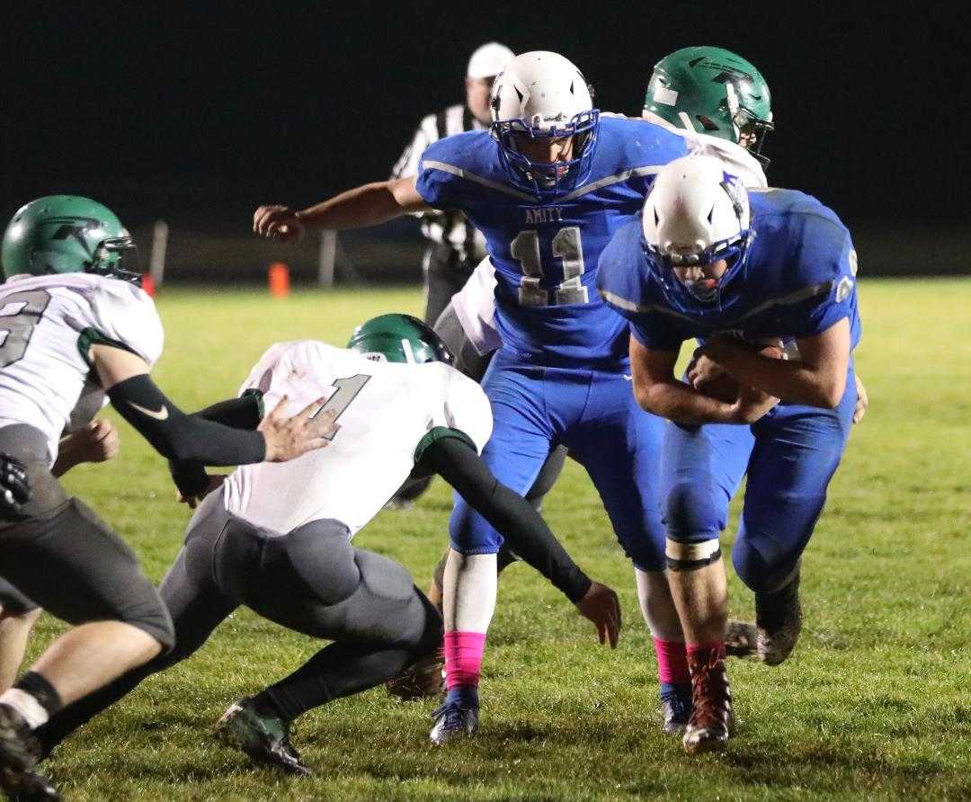 Amity senior Russell Brown bulls down to the 1-yard line as Rainier’s Leo Garretson closes in for the tackle. (Norm Maves Jr.)