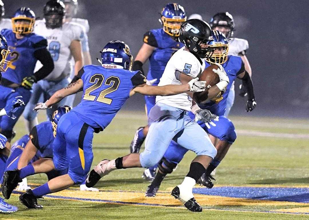 Lakeridge's Jalen John (5) eludes Aloha's Logan Moore (22) on Friday night. (Photo by Jon Olson)