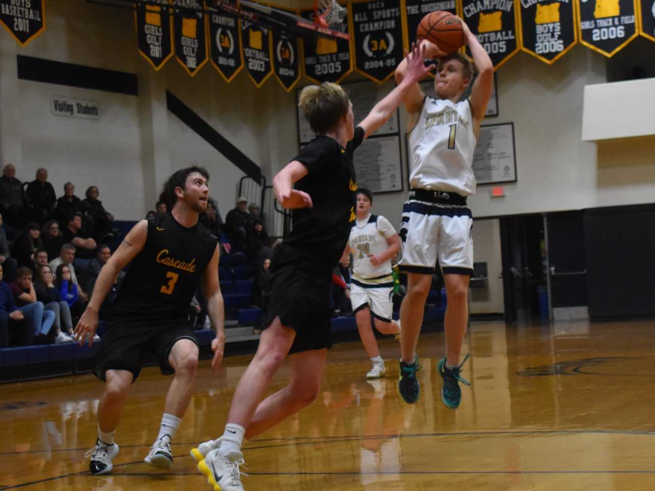 Marist Catholic's Nick Stice shoots over Cascade's Carson Molan on Tuesday night. (Photo by Jeremy McDonald)