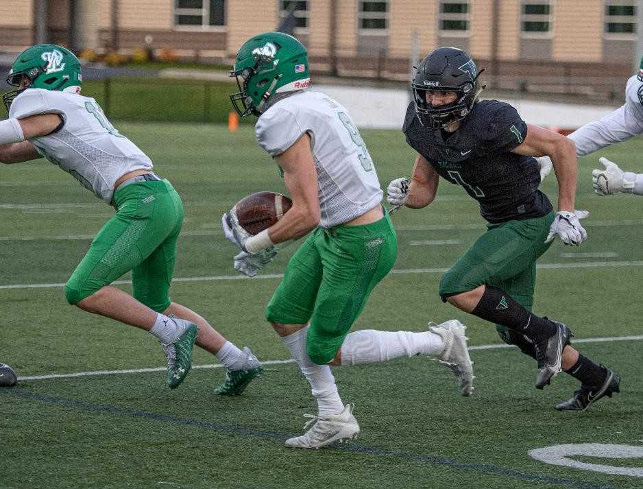 West Linn's Clay Masters, who had two touchdown catches, runs from Tigard's Spencer Kuffel (1). (Photo by Ralph Greene)