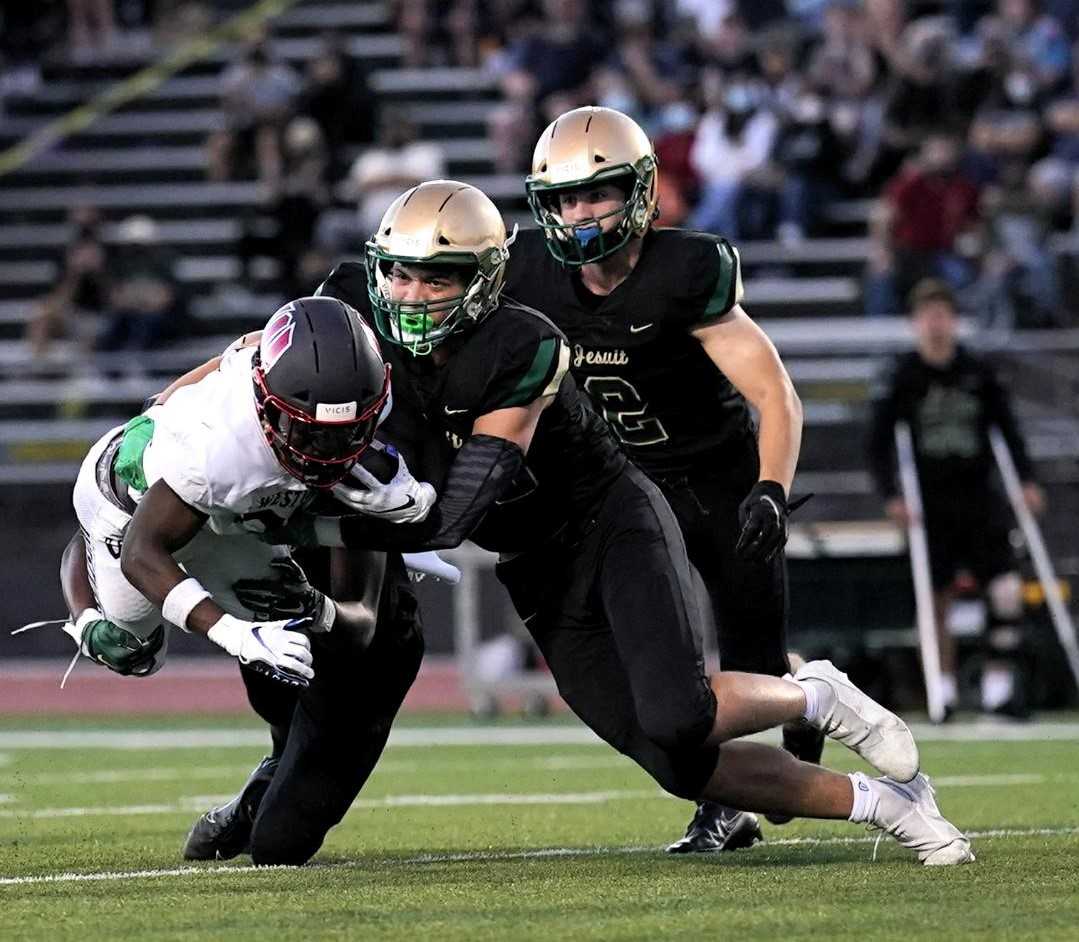 Jesuit's Spencer McKelligon (center) and Garret Speer (2) chase down Westview's Jordan Fisher. (Photo by Jon Olson)