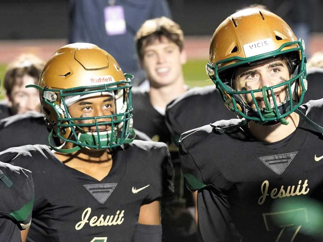 Jace Burton (left) and Jacob Hutchinson listen to coach Ken Potter's message after Jesuit's win Friday. (Photo by Jon Olson)