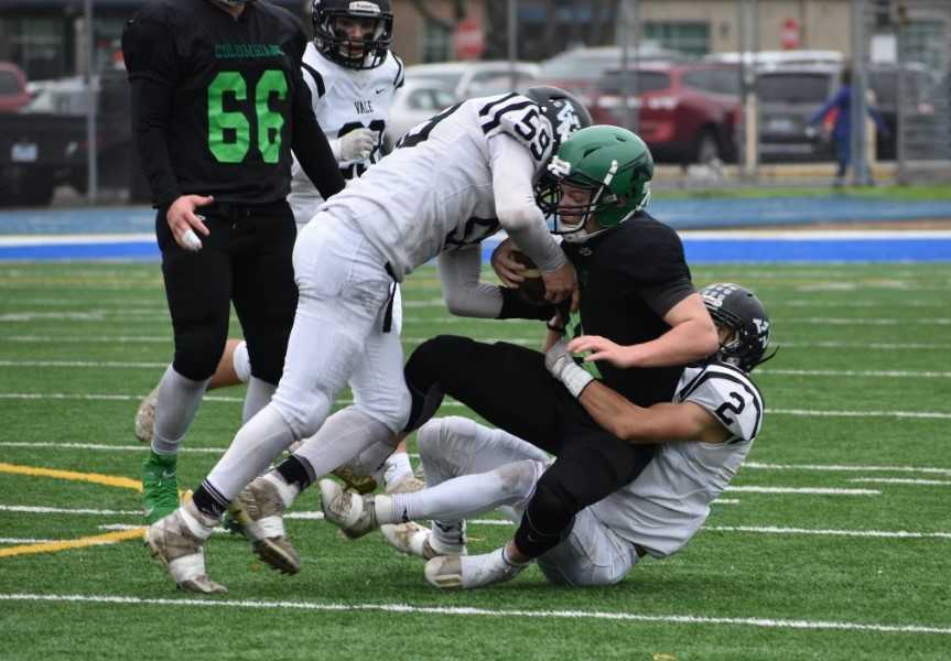 Vale's Jackson Schaffeld (59) and Colt Cummings (2) wrap up Rainier's Stone Ware in Saturday's win. (Photo by Angie Aldred)