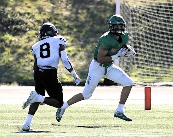 West Linn's Mark Hamper tries to elude Tualatin's Malik Ross (8) in a Three Rivers League game Oct. 2. (Photo by Jon Olson)