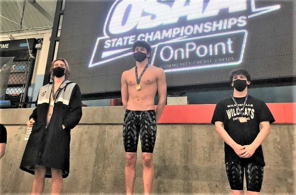 Crater senior Marcus Gentry (center) set an OSAA meet record in the 100 backstroke and a 5A meet record in the 200 IM.