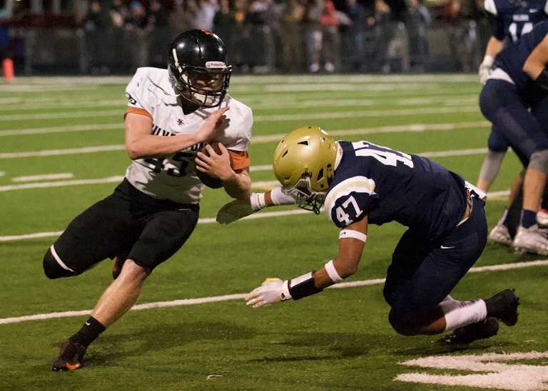 Silverton's Hayden Roth powers through a tackle by West Albany's Cassius McGinty. (Photo by Norm Maves Jr.)