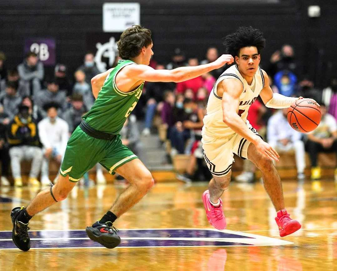 Tualatin's Noah Ogoli, working against the defense of Summit's Julian Mora, scored a game-high 24 points. (Photo by Jon Olson)