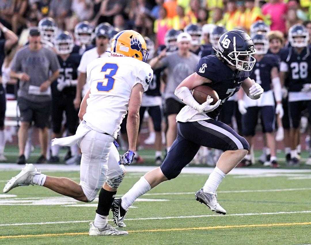 Lake Oswego's Henry Smith, avoiding Barlow's Mason Holland (3), had two touchdown catches Thursday. (Photo by Jon Olson)