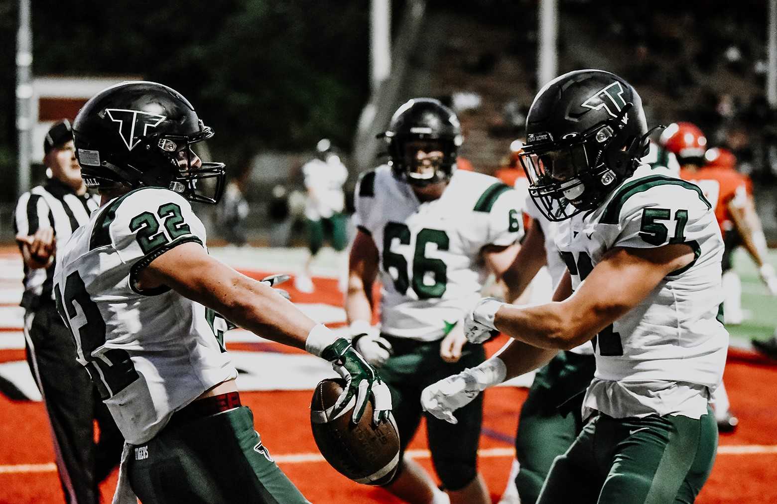 Tigard's Konner Grant (22), celebrating with Boone Koffman (51), rushed for 200 yards Thursday. (Photo by Fanta Mithmeuangneua)