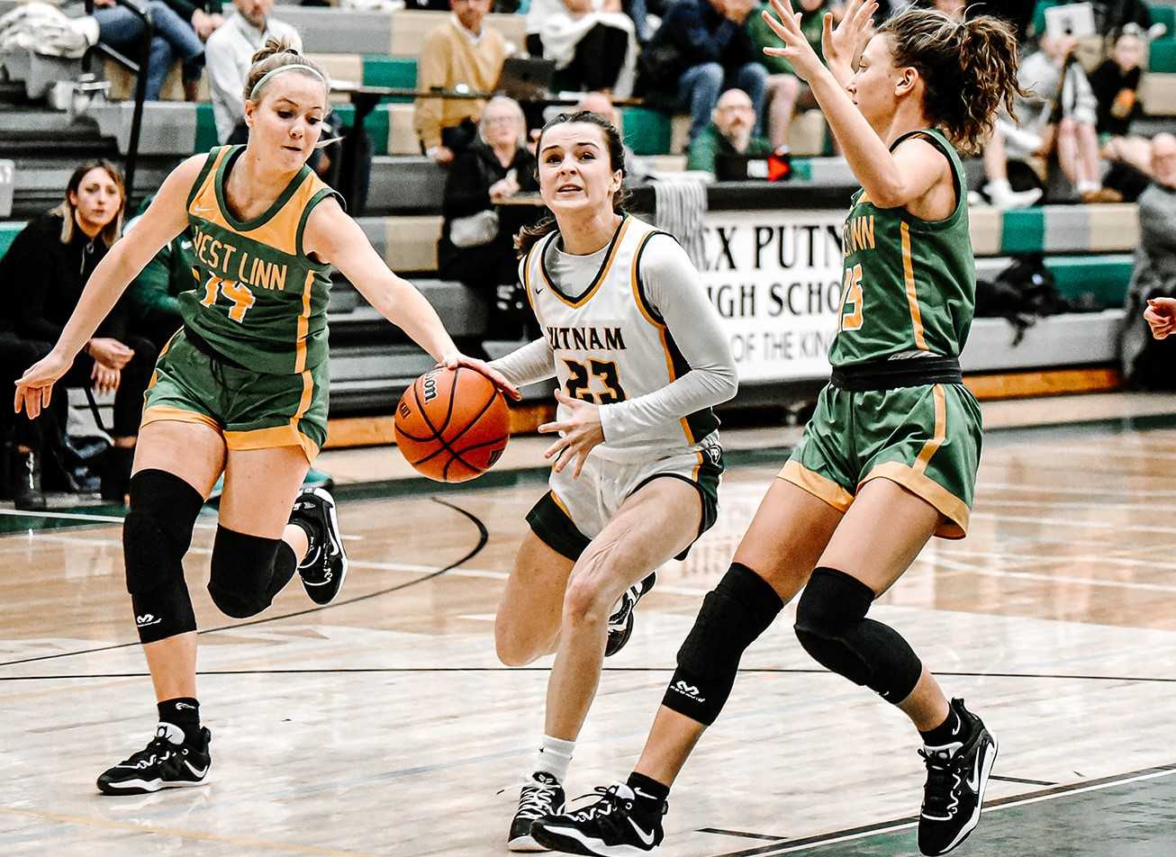 Putnam's Emma McDonald drives between West Linn's Reese Jordan (14) and Sophie Maxwell (15). (Photo by Fanta Mithmeuangneua)