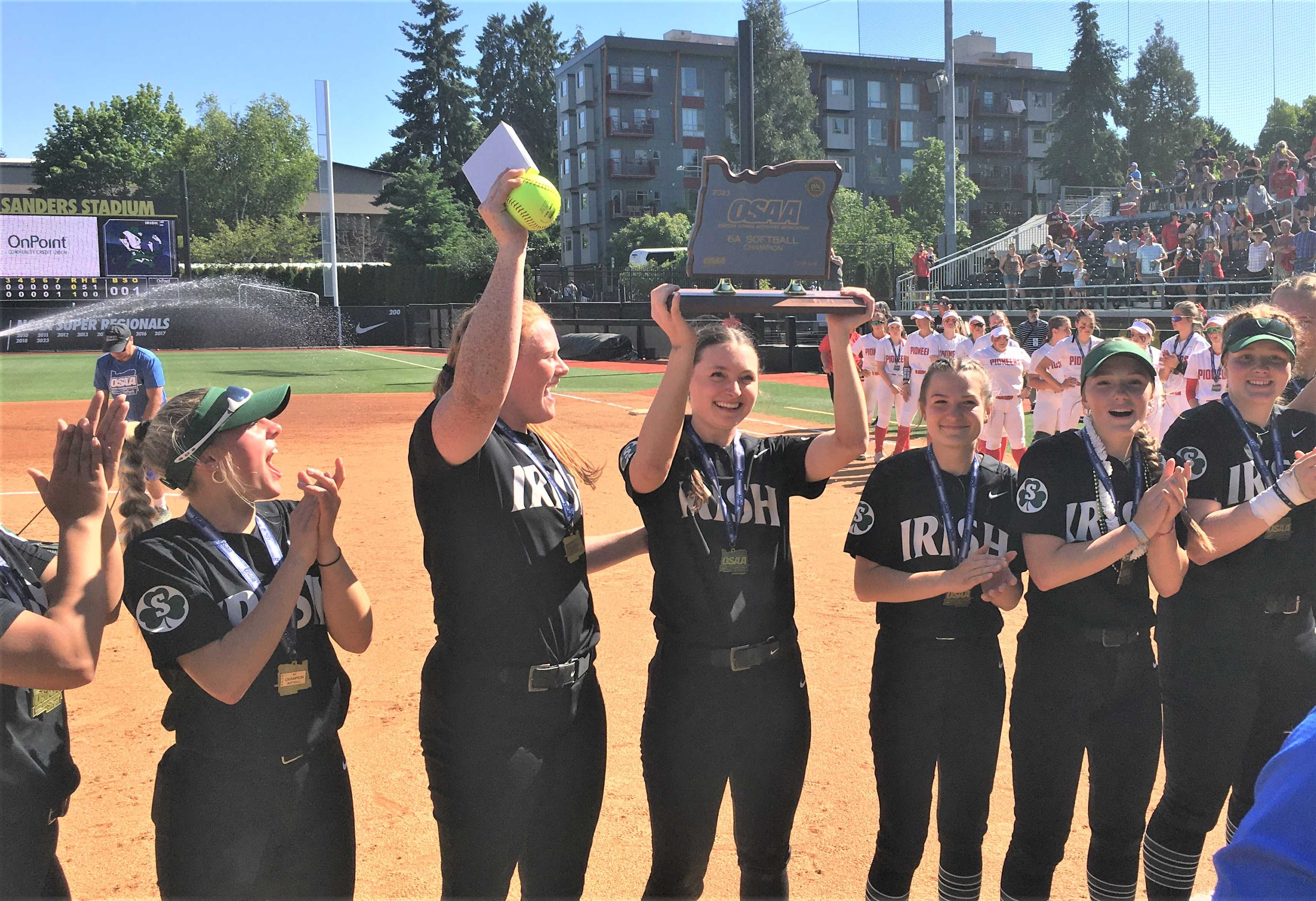 Sheldon's Payton Burnham (with ball) and Meara Sain (with trophy) celebrate after beating Oregon City on Saturday.