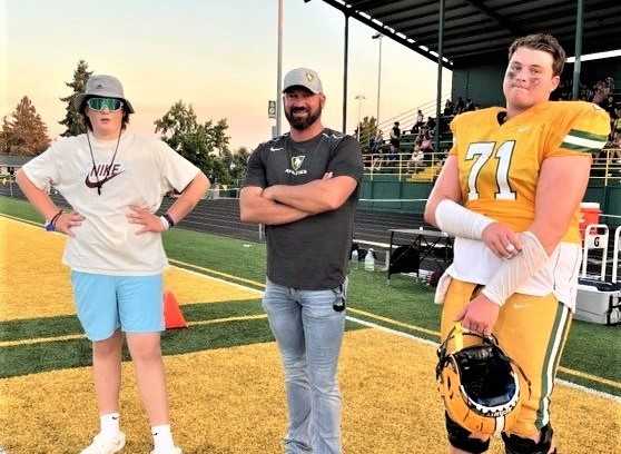 Athletic director Jesse Eveland, with sons Peyton (left) and Jace (right), is heading from Putnam to Redmond for 2023-24.