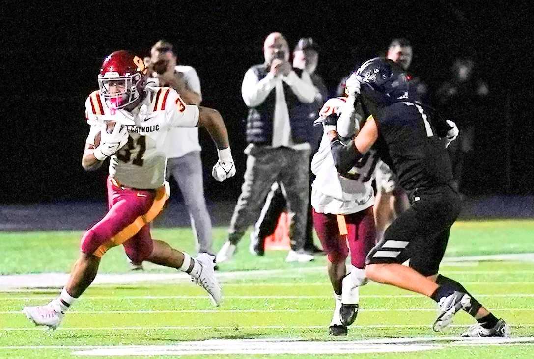 Central Catholic's Tyson Davis (31) uses a block by D'Marieon Gates (21) to score on a 63-yard pass Friday. (Photo by Jon Olson)