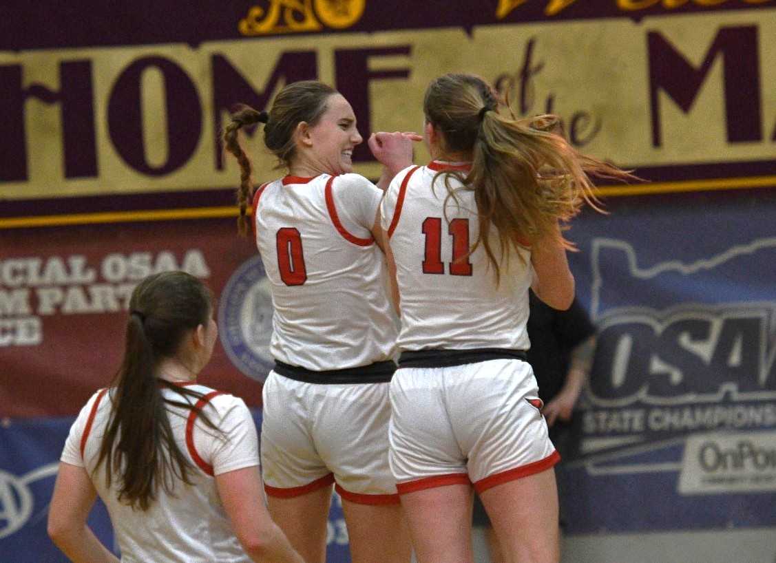 Corbett's Ally Schimel (0) and Ella Holwege (11) celebrate after Schimel made a three-pointer Saturday. (Photo by John Gunther)