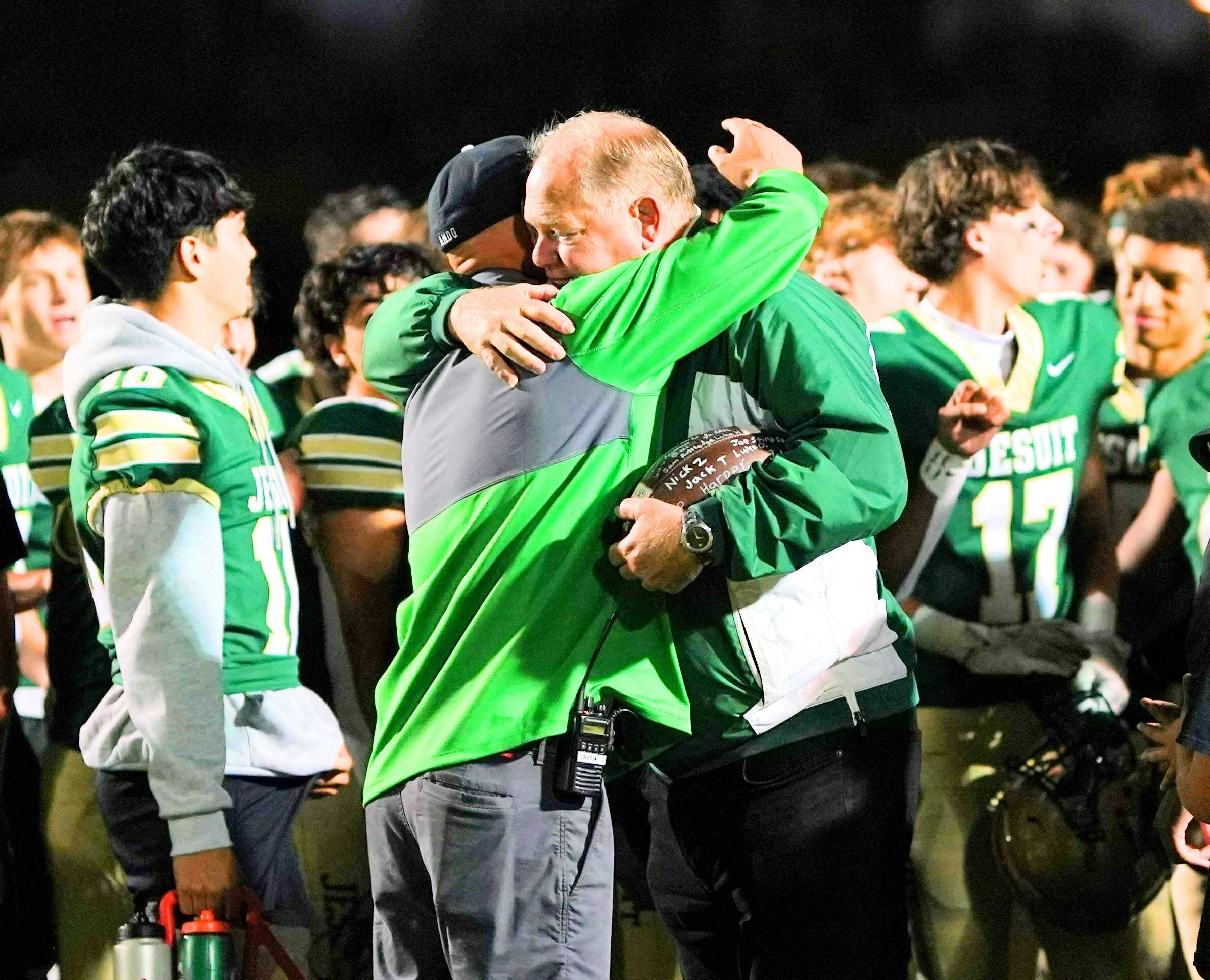 Jesuit coach Ken Potter (right) embraces athletic director Colin Griffin after the Crusaders' win Friday. (Photo by J.R. Olson)