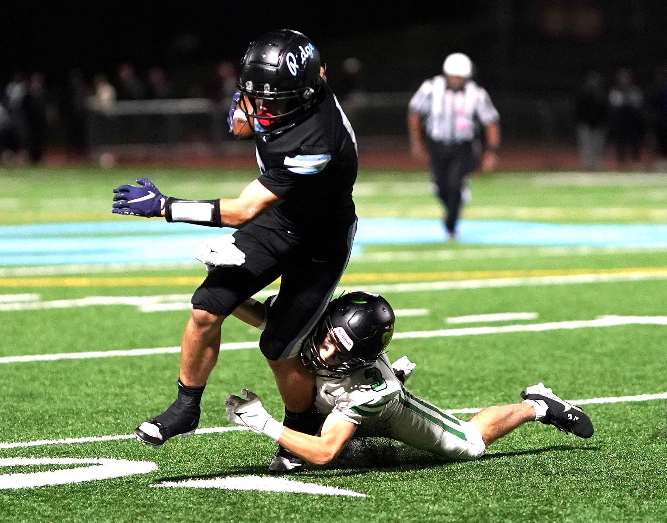 West Linn's Tripp Moussavi (3) brings down Lakeridge quarterback Drew Weiler on Friday night. (Photo by J.R. Olson)