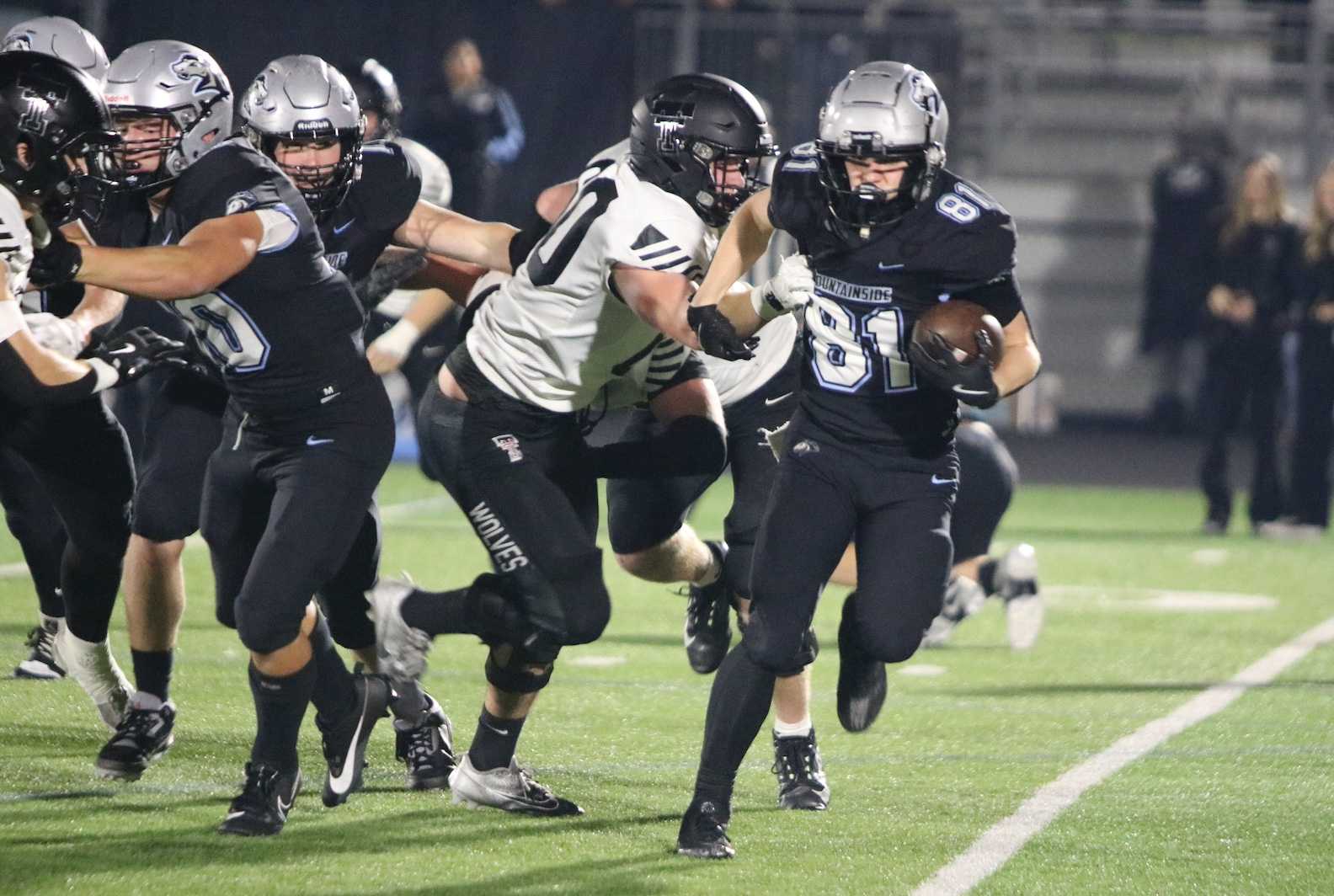 Mountainside's Reece Ballew (81) eludes Tualatin's Luke Schwab during Friday's 6A football playoff game. (Jim Beseda photo)