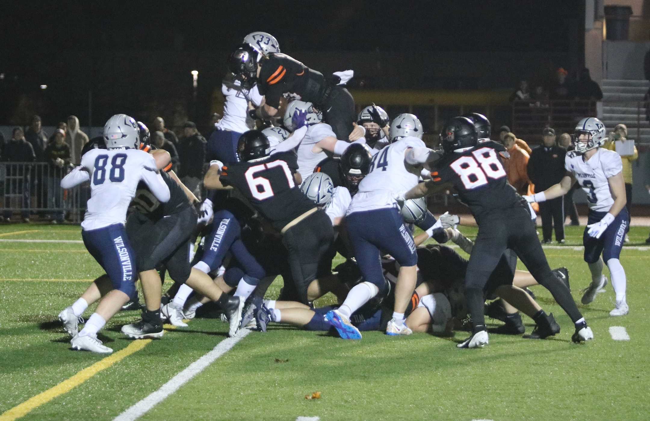 Wilsonville's Drake Devin (33, top) helps stop Silverton's Sawyer Teeney short of the goal line in Friday's 5A semifinal.