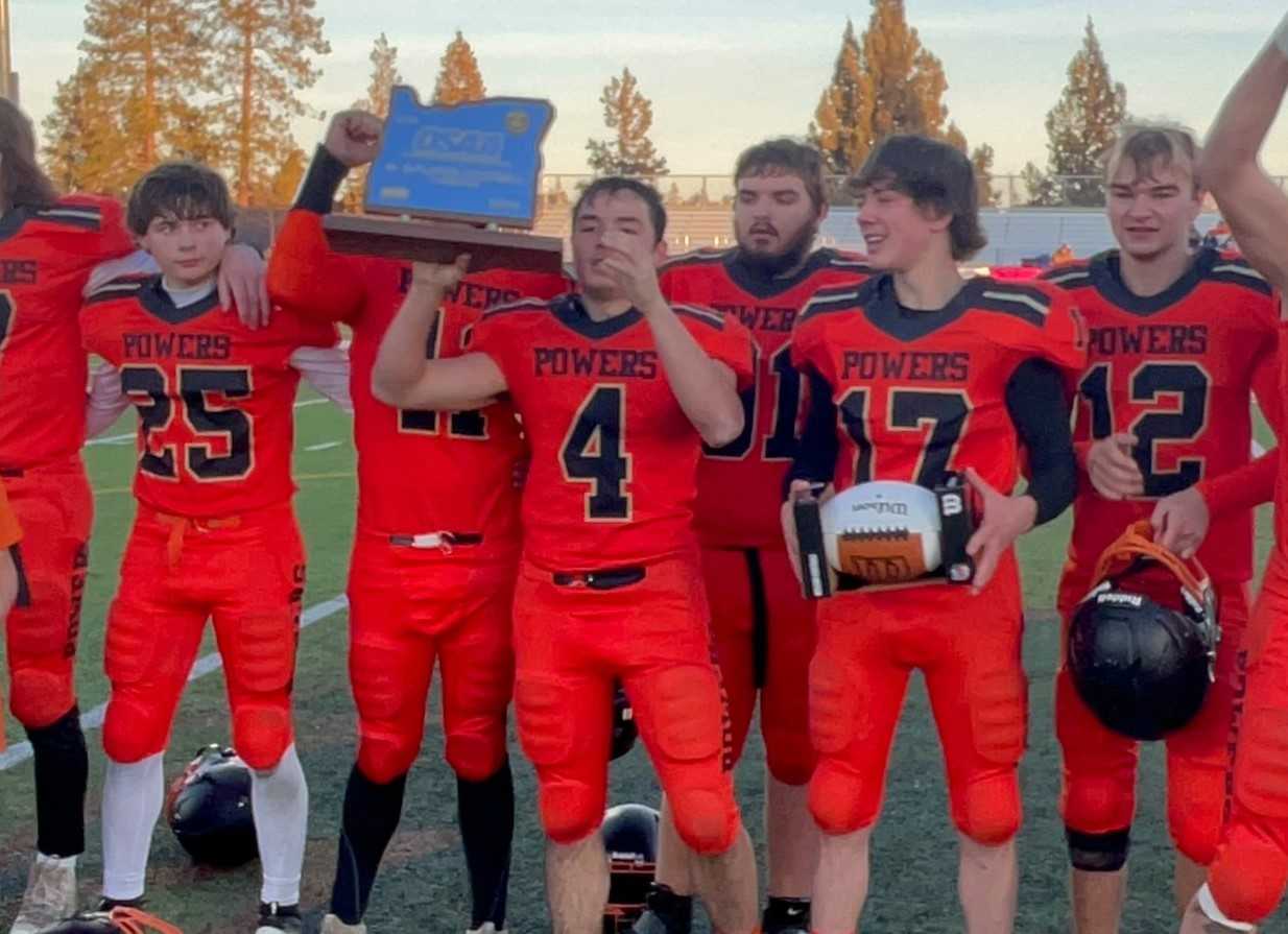 Powers senior Patrick Mahmoud (4) holds the state championship trophy after the Cruisers' win Saturday.