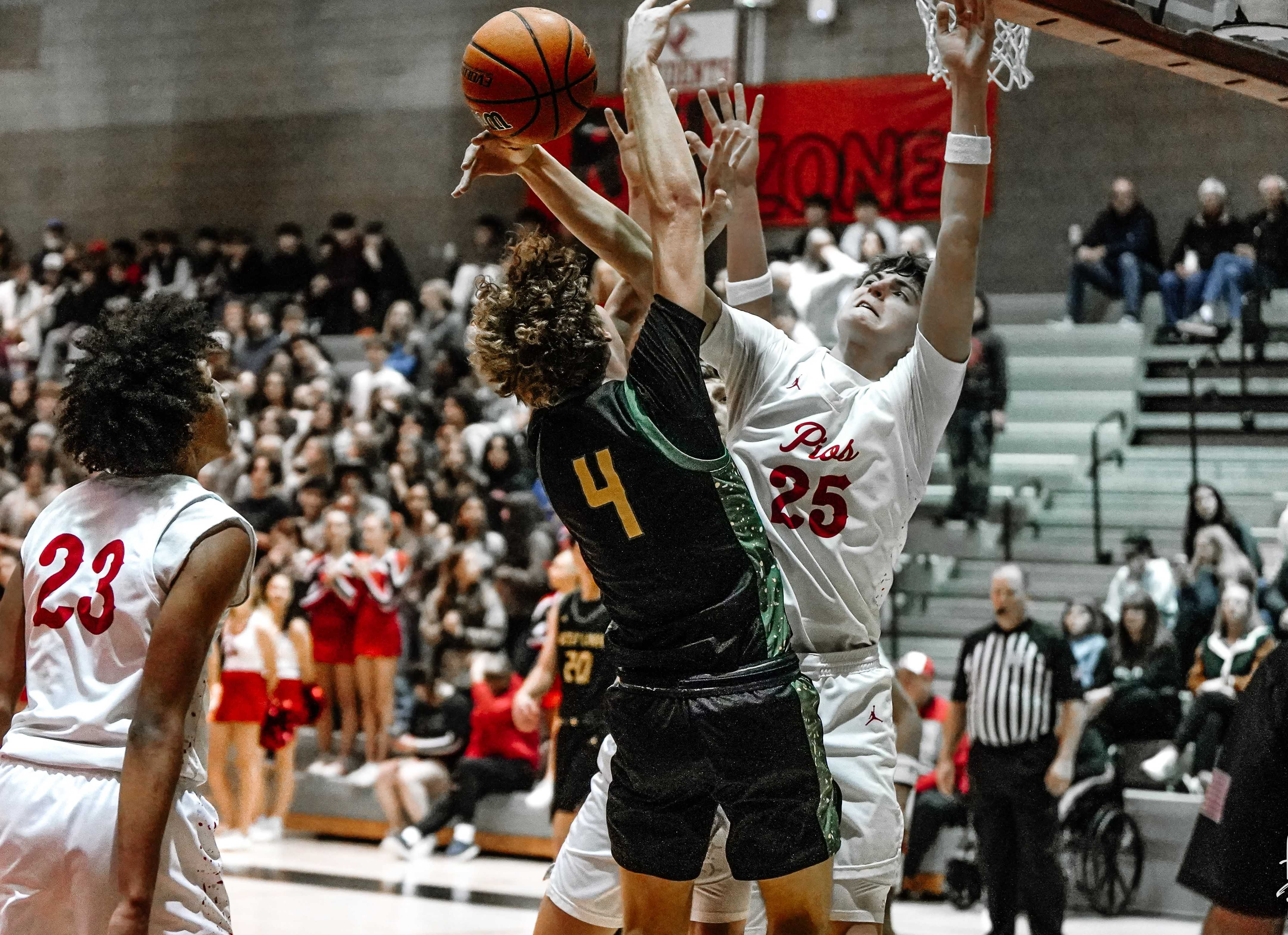 Oregon City's Eli Hopkins (25) turns away West Linn's Sawyer Young (4) in Friday's game. (Photo by Fanta Mithmeuangneua)