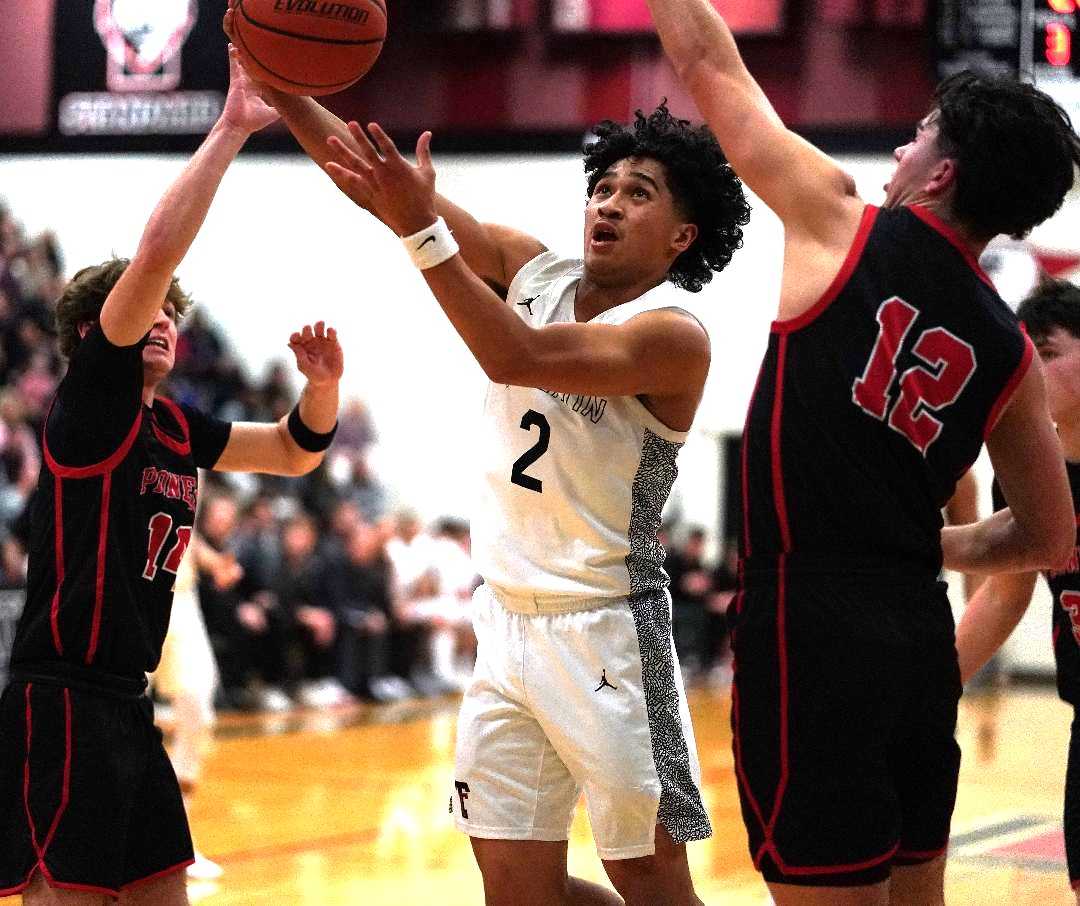 Tualatin sophomore Pat Vialva Jr., driving against Oregon City, is averaging 17.9 points this season. (Photo by J.R. Olson)