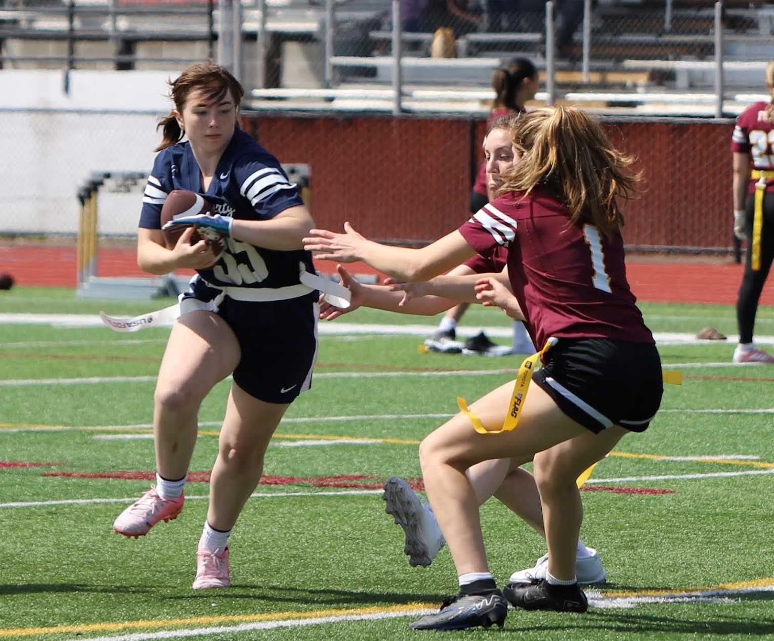 Liberty senior Addison Furjanic (left) tries to evade Forest Grove defenders in a flag football game. (Photo by Rian Decker)