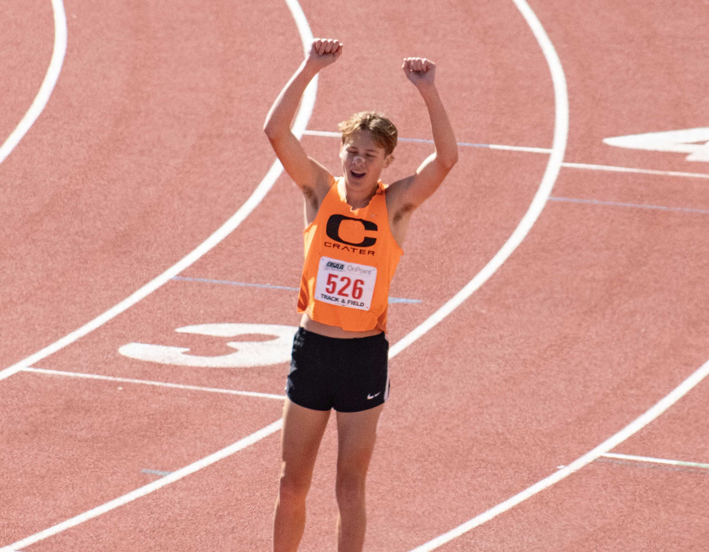 Crater's Tayvon Kitchen is jubilant after setting a state record in winning the 3,000 meters Friday. (Photo by Chris Burkhardt)