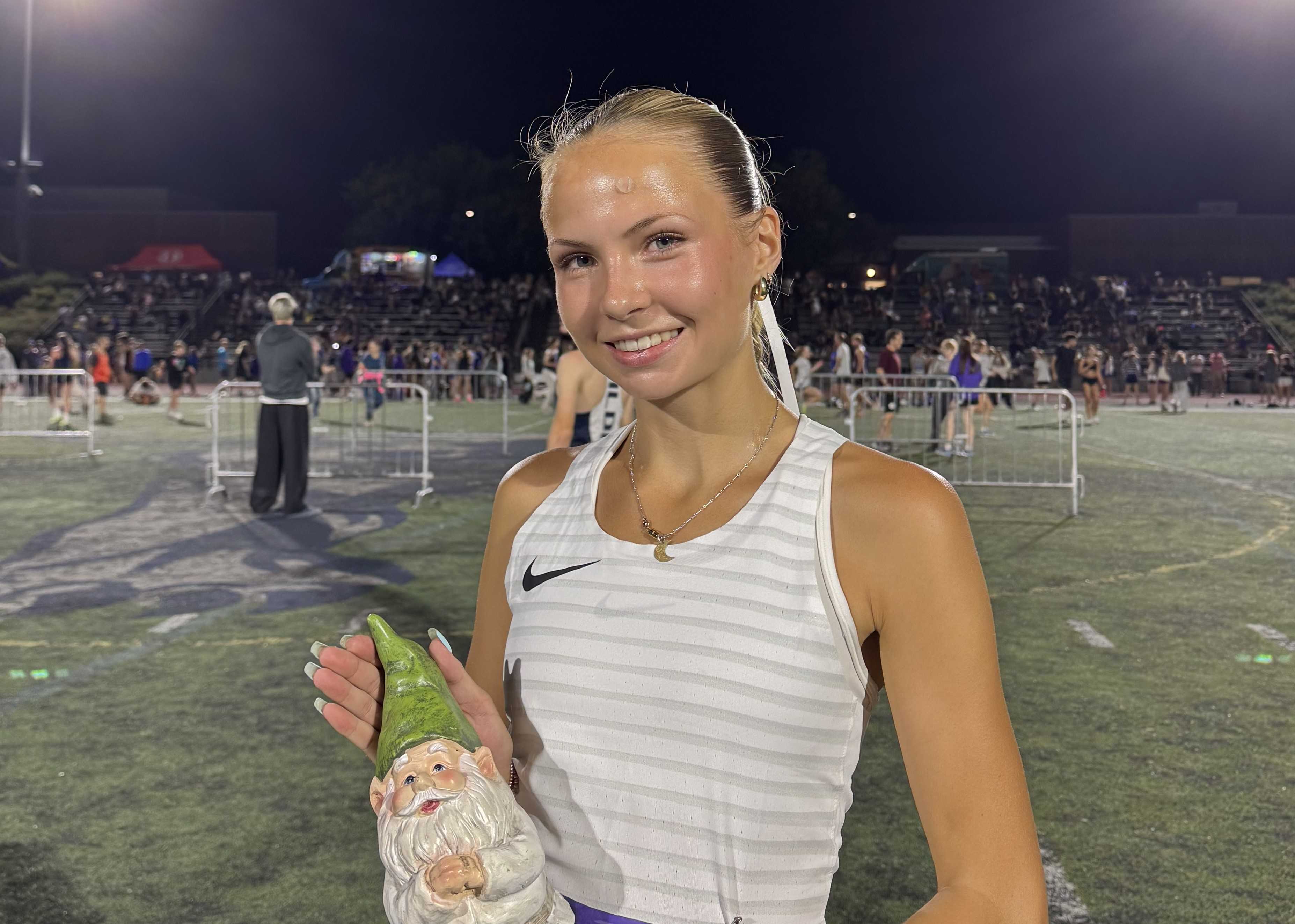 Lincoln junior Ellery Lincoln poses with the Night Meet garden gnome trophy after her win Friday night. (Lincoln HS)