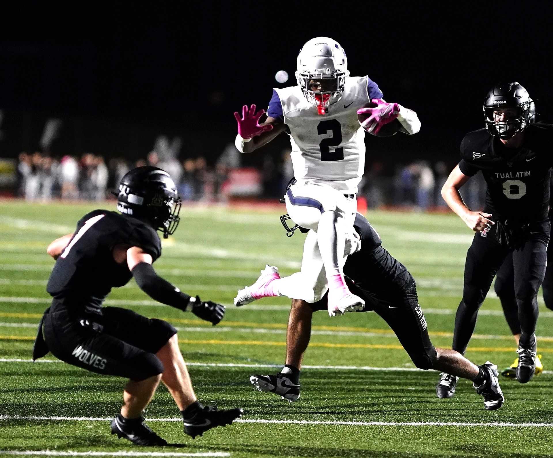 Lake Oswego's LaMarcus Bell skips through the Tualatin defense for one of his four touchdowns Friday. (Photo by J.R. Olson)