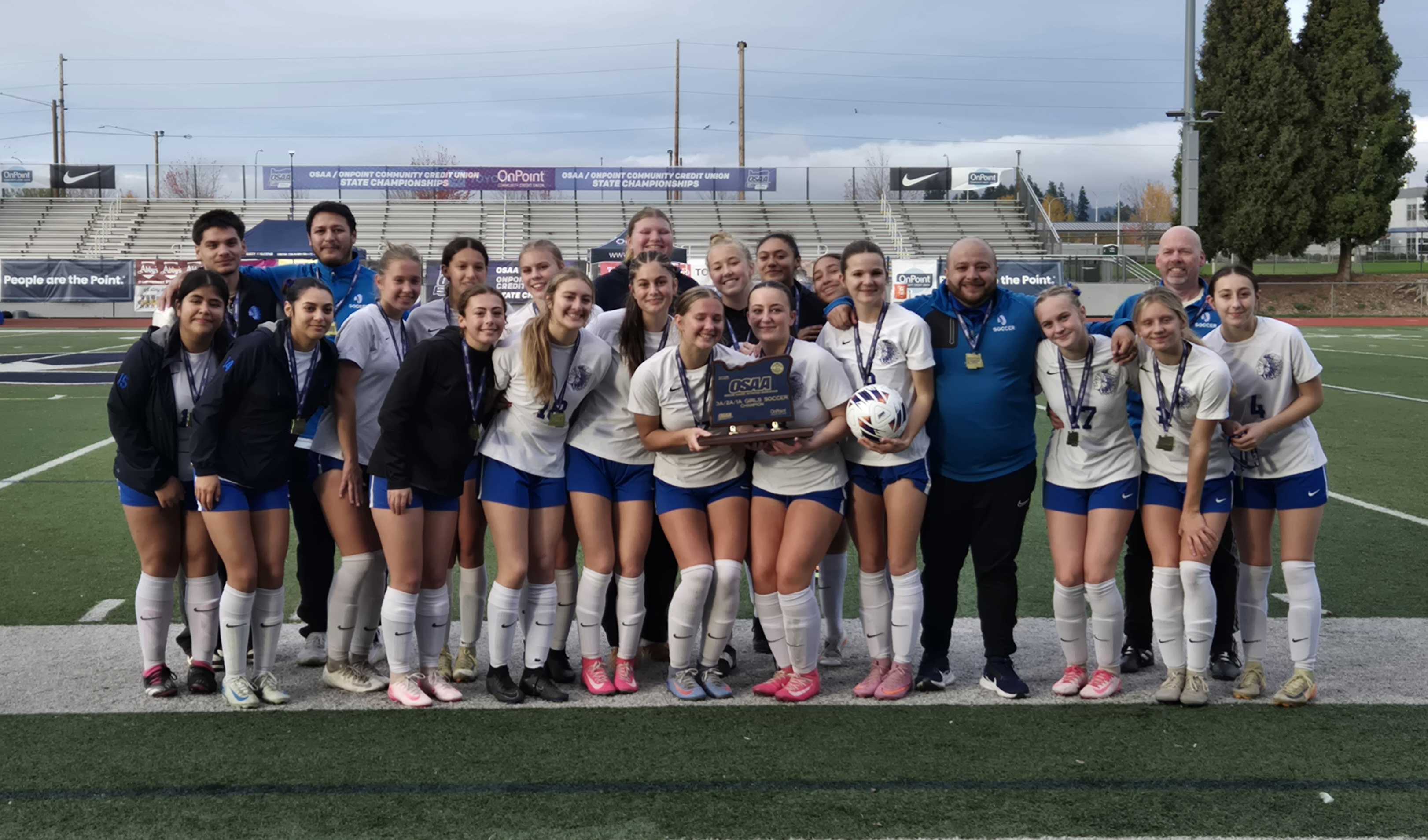 The Amity girls soccer team celebrates with the trophy after winning the state title. (Photo by Austin White)