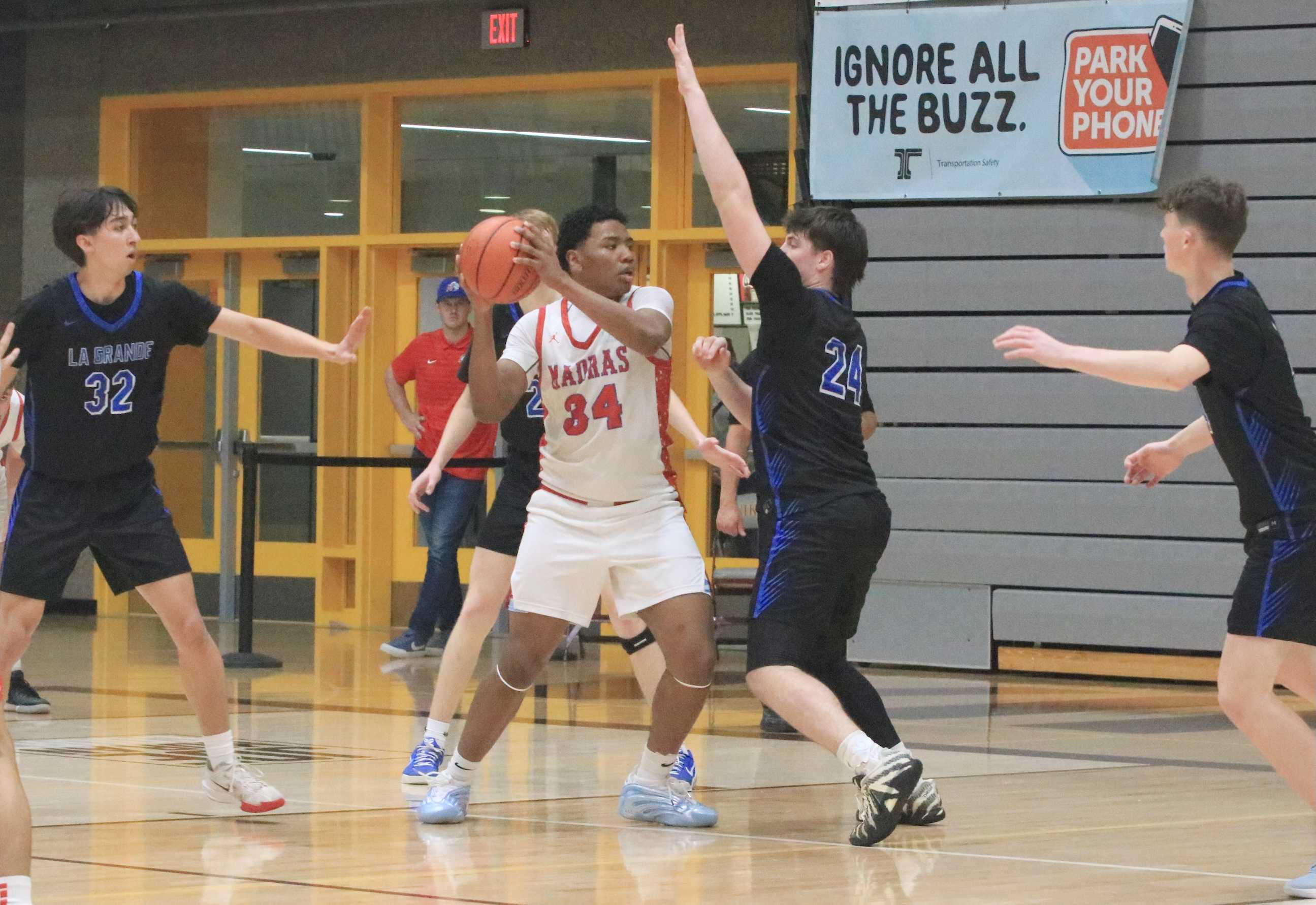 Madras' Matthew Suppah-Scott draws pressure from La Grande's Darek Mcilmoil during Friday's 4A boys basketball semifinal.