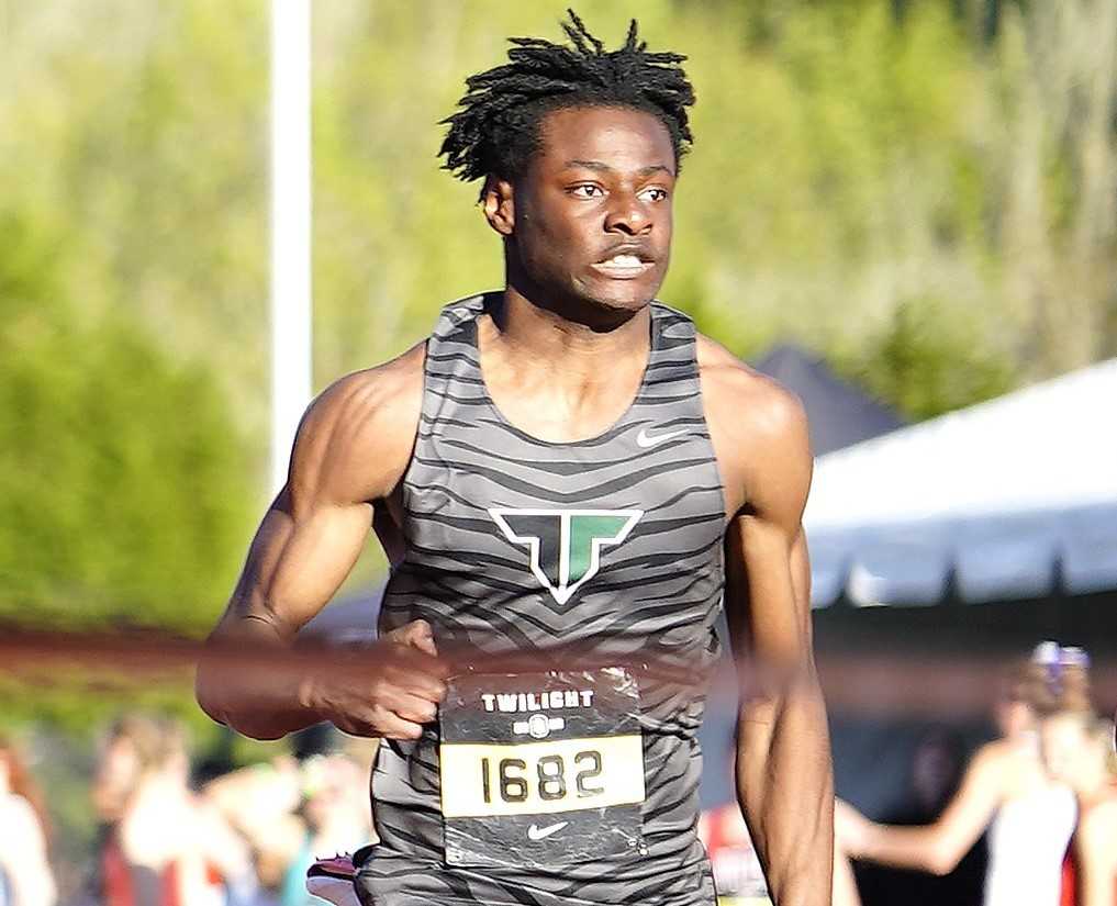 Tigard senior Marcus Burton wins the Elite 100 meters in the Nike/Jesuit Twilight Relays on April 24. (Photo by J.R. Olson)
