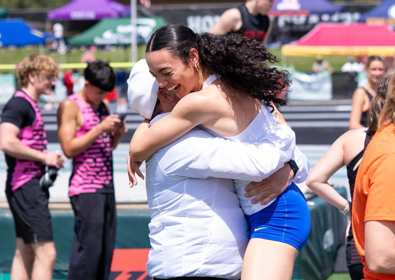 Newberg's Sophia Castaneda celebrates with coach Brandon Ramey after setting the 400 state record. (Photo by Aaden Eggert)