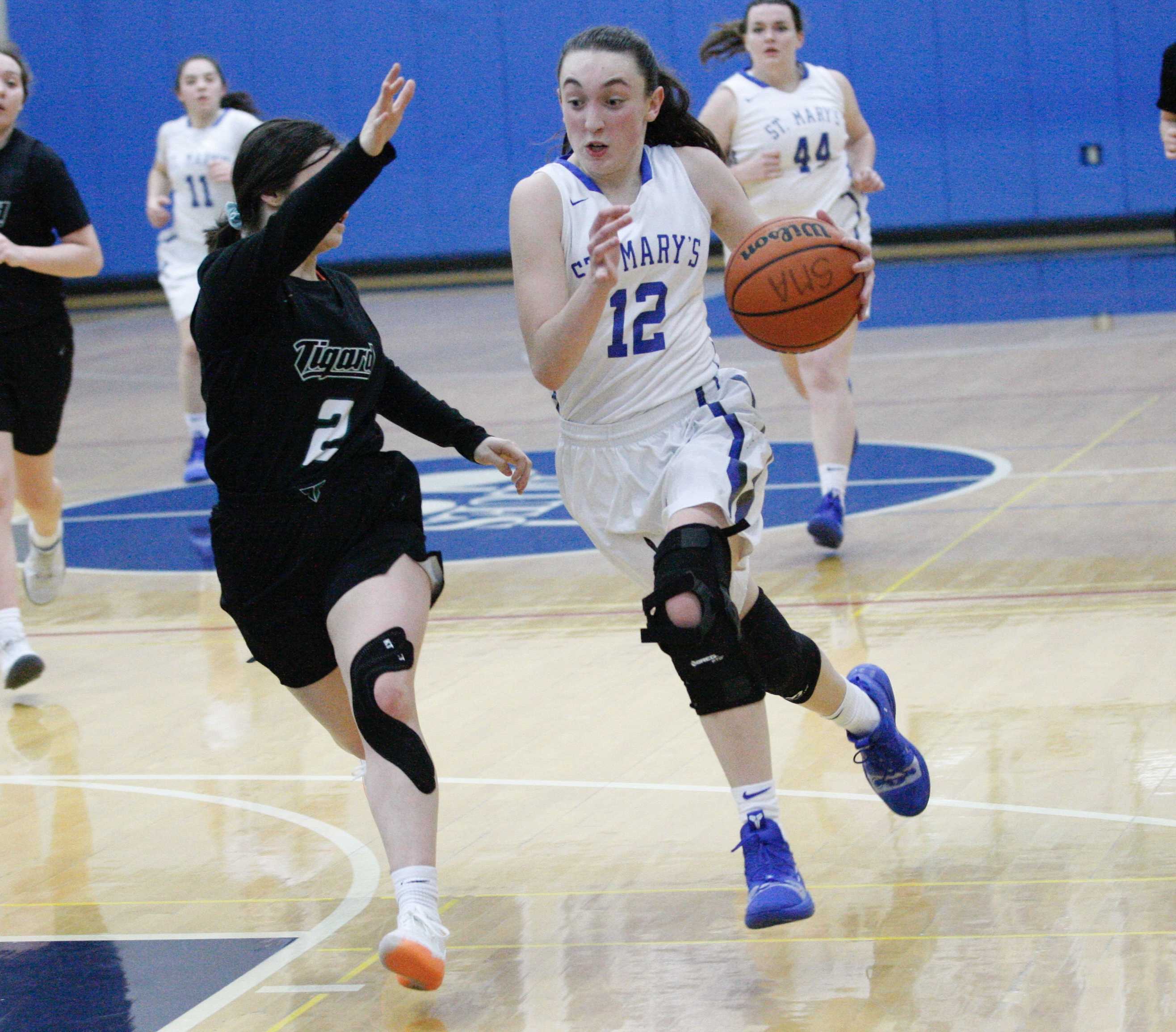 St. Mary's Academy's Anna Eddy drives into Tigard's Kennedy Brown on her way to a 14-point night. (Photo by Norm Maves Jr.)
