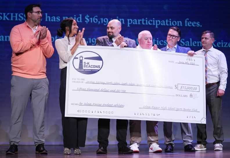 Salem-Keizer athletic directors pose with a $15,000 check from the booster club at the Beacon Awards. (Statesman-Journal)