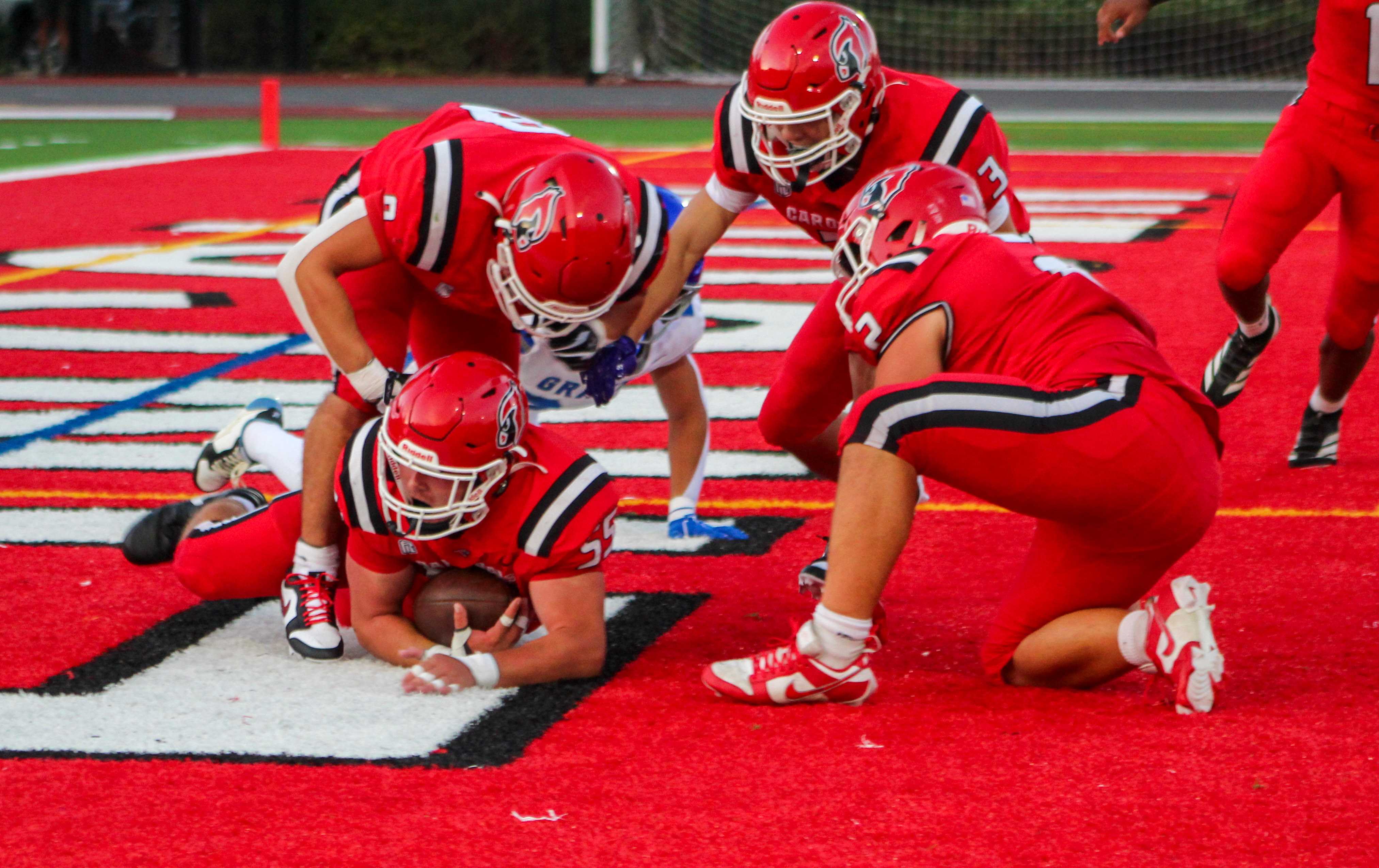 Lincoln football players fall on a fumble in the end zone in a 28-7 win over Grant. (Photo by Austin White)