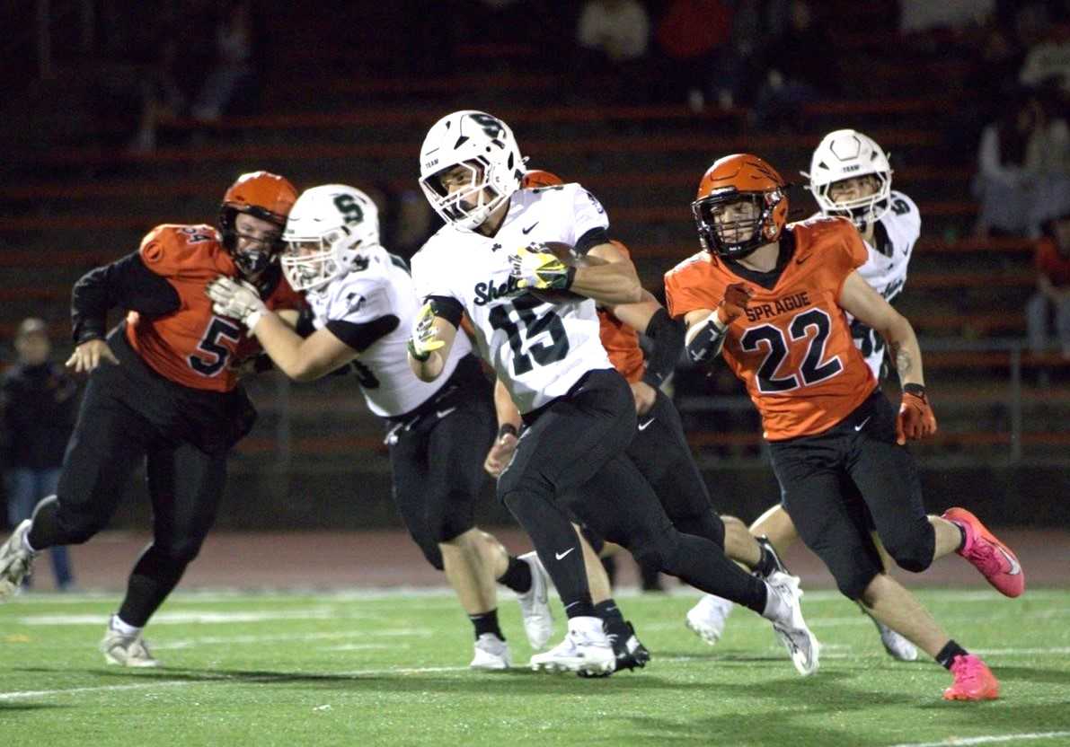 Sheldon's Chase Colling (15) runs away from Sprague's Gabe Flynn (22) in Friday's 6A nonleague game. (Photo by Tiffany Garboden)