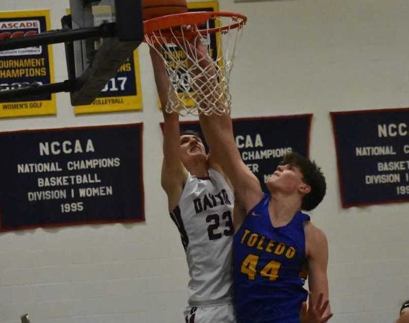 Dayton's Jaysen Howard (23) is met at the rim by Toledo's Jaxon Rozewski. (Photo by Jeremy McDonald)