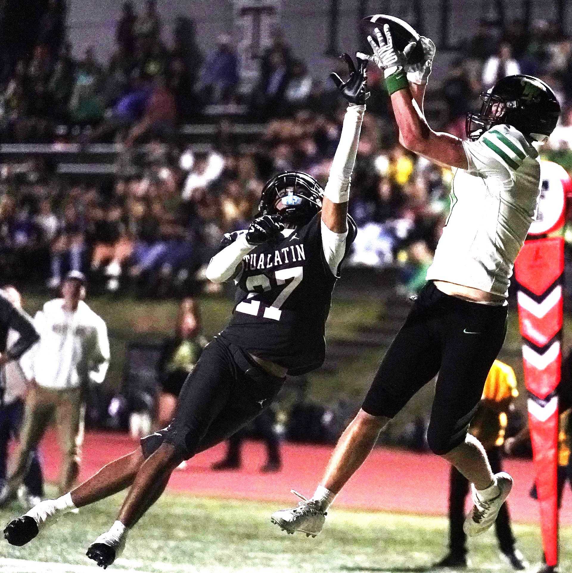 West Linn's Tyson Donnerberg catches a touchdown pass over Tualatin's D'Ayvion Futter on Friday night. (Photo by JR Olson0