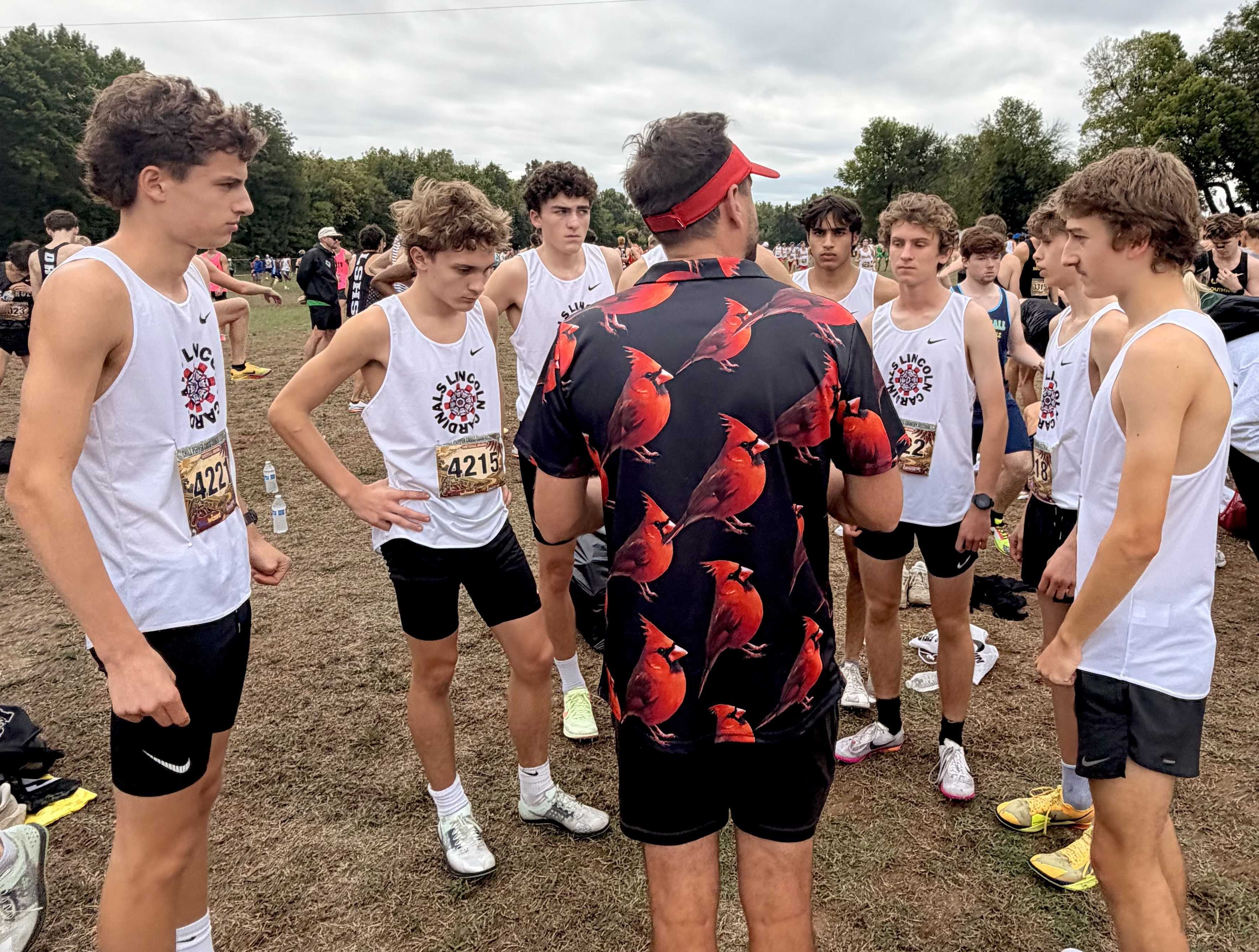 Lincoln coach Eric Dettman addresses his boys team prior to the Chile Pepper Festival race Saturday in Arkansas.