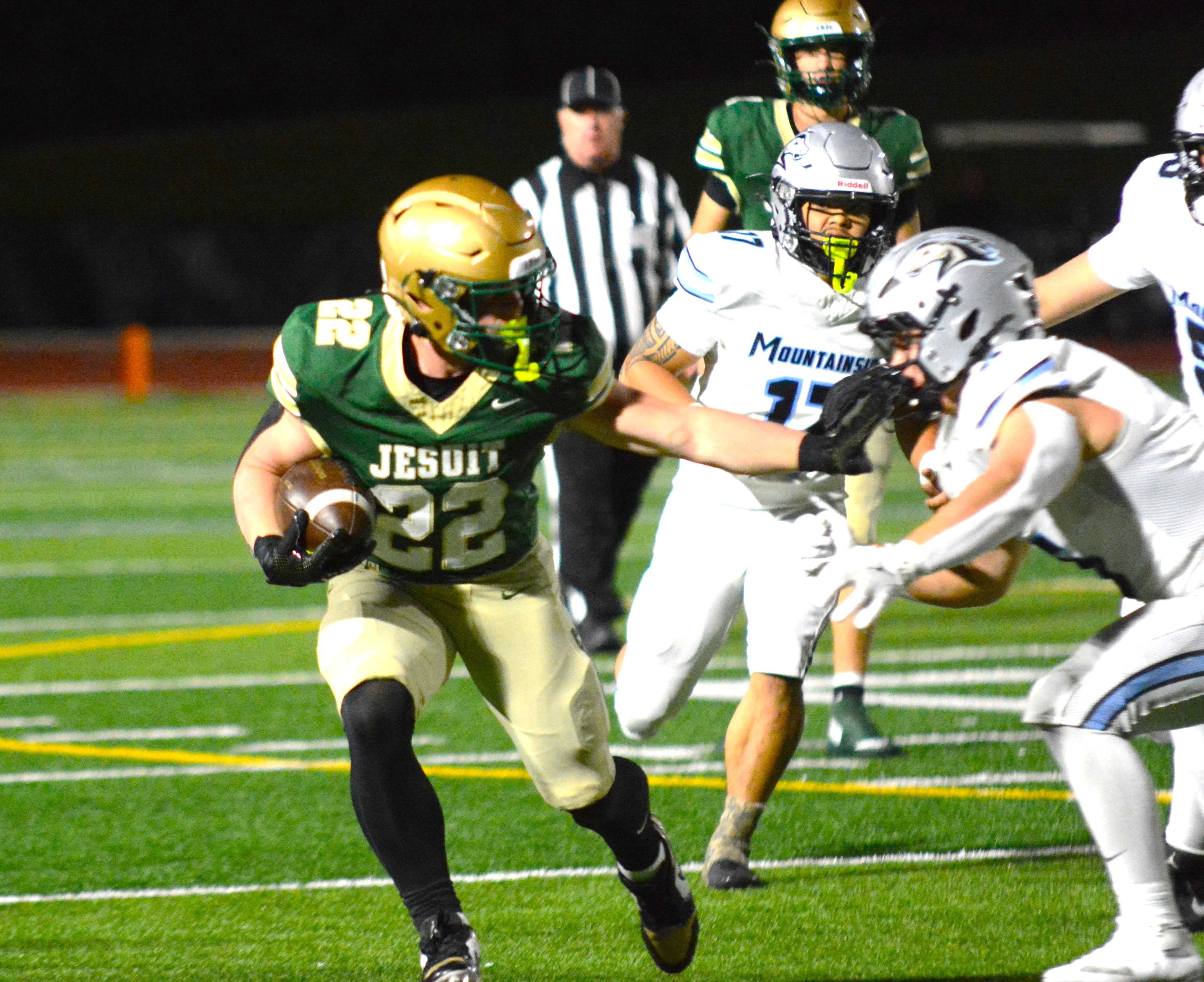 Jesuit's Luke Ortner evades Mountainside defenders on his way to 158 rushing yards in Friday's win.(Photo by Wade Evanson)