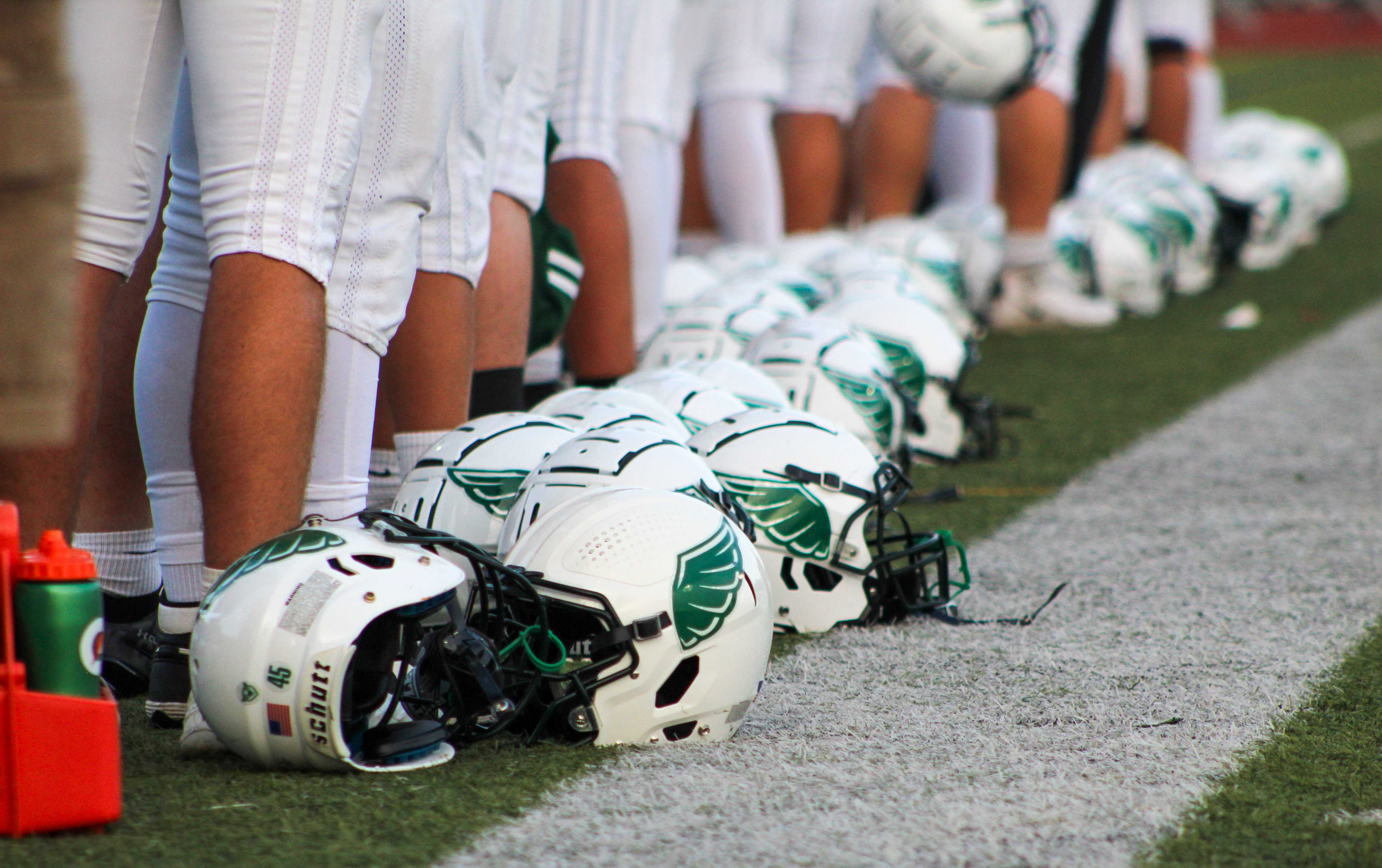Ida B. Wells football lines up for the national anthem ahead of a game against Roosevelt. (Photo by Austin White)