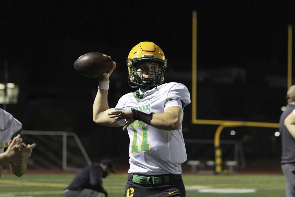 Cleveland QB Jude Buck warms up against Roosevelt. (Photo by Ben Teese)