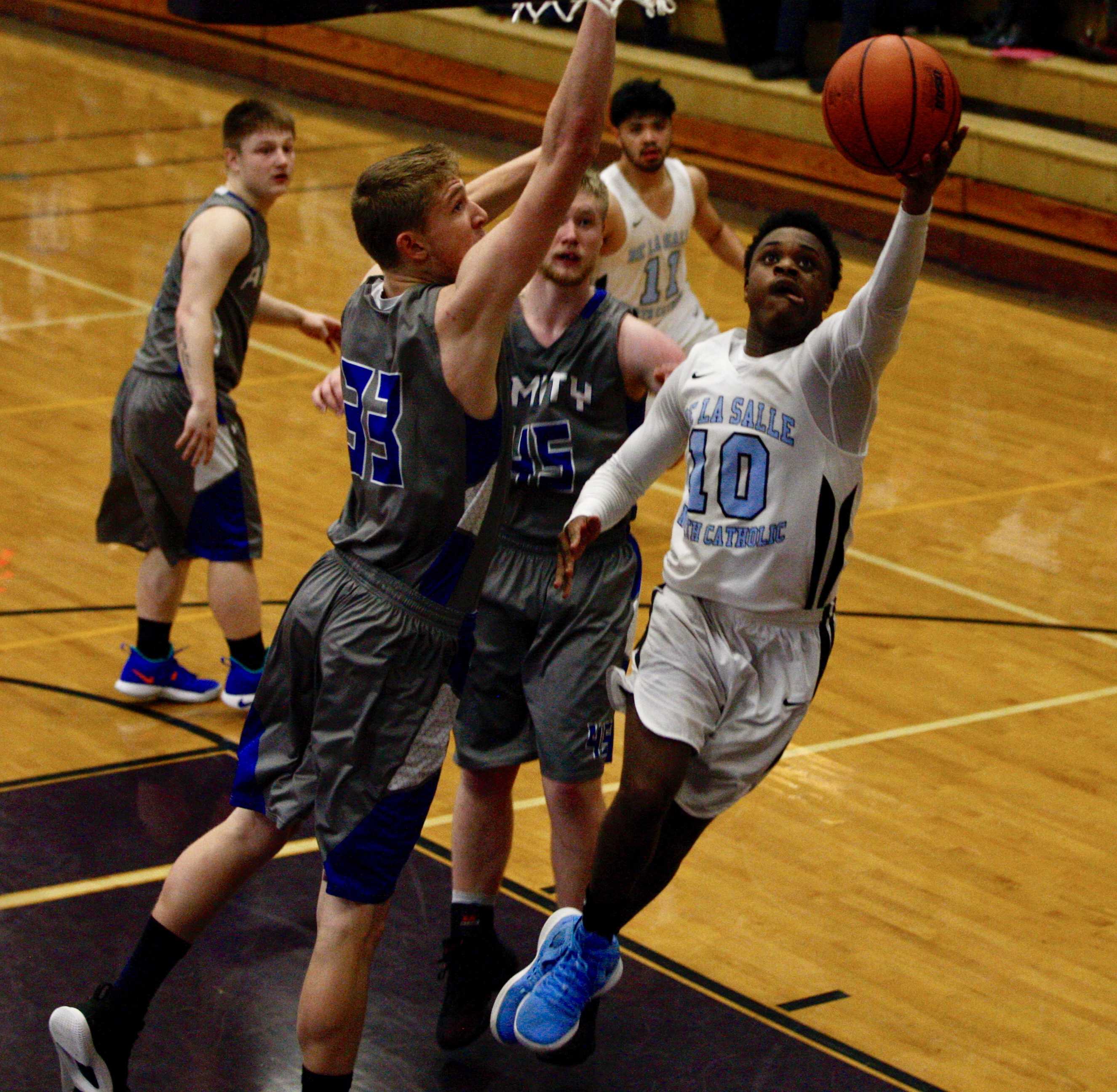 De La Salle North Catholic's Anthony Mosley slashes past two Amity defenders to score two of his 18 points (Norm Maves Jr.)